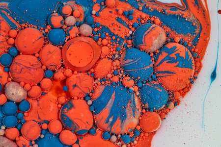 Bubbles popping in acrylic pouring of oil and blue gold orange and white paints in abstract background assetの写真素材
