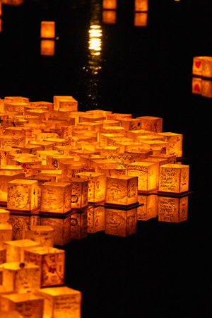 Night shot of lanterns at festival on calm black riverの写真素材