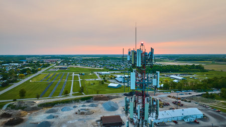 Radio Tower over quarry, distant homes houses neighborhood, sunset on top of structure aerial