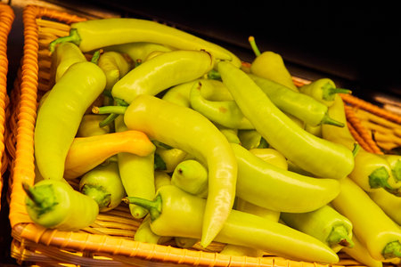 Yellow banana peppers in basket with black background assetの写真素材