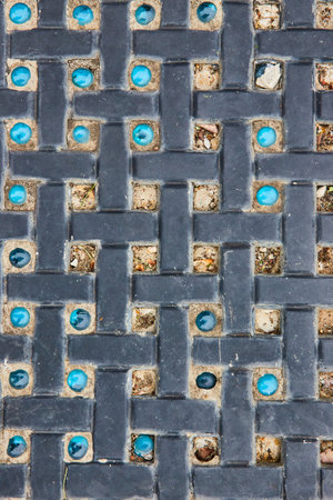Crisscrossing pattern with varying and missing blue marble stones between bricks