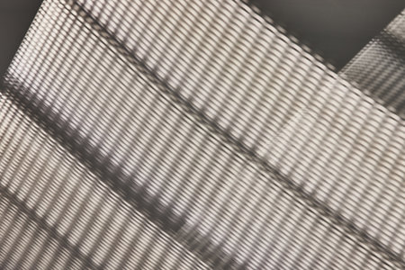 Light poking through woven type material creating abstract art in grayscale