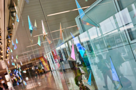 Abstract glass art on glass window with abstract geometric shapes and reflection of peopleの写真素材