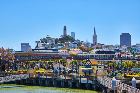 Busy coastline near Pier 39 docks with Coit Tower on distant hillの写真素材