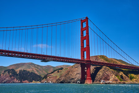 Close up of Golden Gate Bridge with bright summer day with blue skies and choppy bay watersの写真素材
