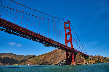 Underside and side view of Golden Gate Bridge with choppy San Francisco Bay watersの写真素材