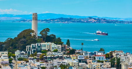 Coit Tower atop Telegraph Hill overlooking boats in San Francisco Bay aerialの写真素材