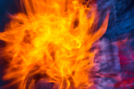 Abstract view of orange and yellow flames with blue and purple smoke background assetの写真素材