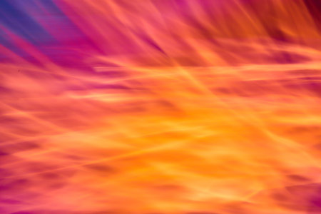 Abstract bright orange and yellow flames with pink and purple edges background assetの写真素材