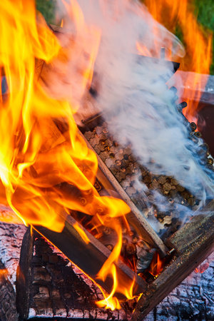 White smoke and yellow orange flames eating away at burning beehive as metaphor for dying beesの写真素材
