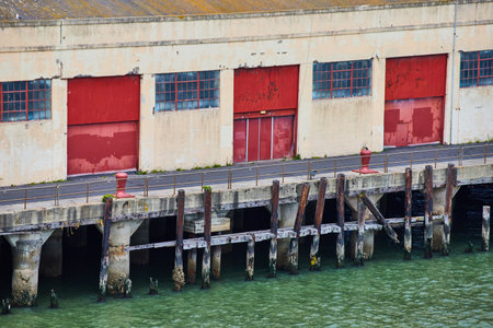 Red doors on pier warehouse with green San Fransisco Bay watersの写真素材