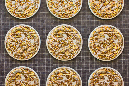 Close up of three golden dragon coins on black tile backgroundの写真素材