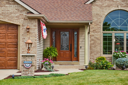 Brown wooden front door with light brown brick and large front window of suburban houseの写真素材