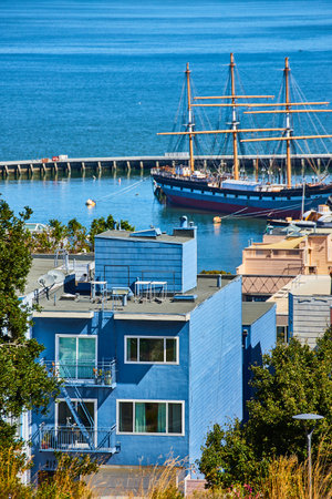Pirate ship in San Francisco Bay with blue house overlooking water