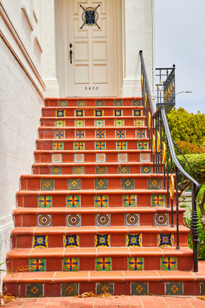 Red brick steps with painted designs on each stair leading to white door