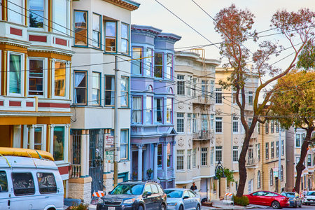 Side view of other fancy houses near The Painted Ladies with varying colors and street cars