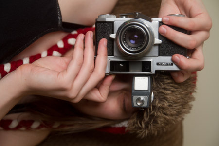 Young Woman holding Camera Sideways in Fun Photographer Pose with Vintage Film Camera