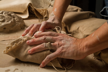 Artisan Working Wet Clay Wrapped in Beige Canvas on Crafting Table
