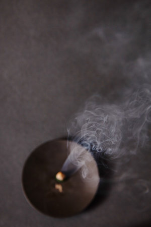 Meditative Glow of Incense Ember with Rising Smoke Patternsの写真素材