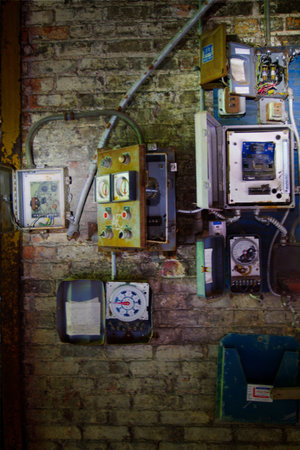 Vintage Industrial Decay: Weathered Electrical Panels on Distressed Brick Wall