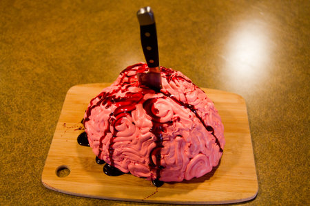 Halloween Themed Brain Cake on Wooden Cutting Board with Knifeの写真素材