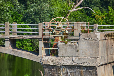 Rusty emergency valve Maumee River Dam on crumbling concrete pilar on sunny summer day Fort Wayne, INの写真素材