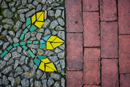 Split image, red bricks beside gravel stones with abstract mosaic of flowers painted rocks pattern