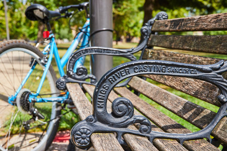Ornate Park Bench and Bicycle in Urban Green Space Close-Upの写真素材