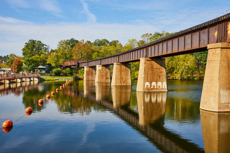 Rustic Railway Bridge Over Huron River with Buoys, Michiganの写真素材