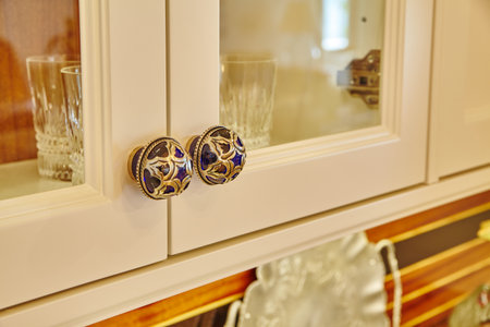 Vintage Blue and Gold Cabinet Knobs with Glassware Backgroundの写真素材