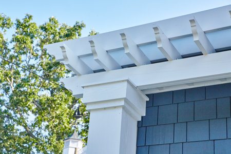 Elegant Suburban Home Roof and Pergola Detail Against Blue Sky