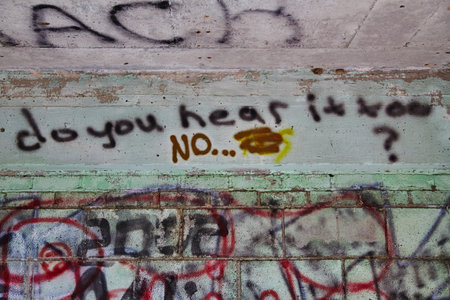 Graffiti Dialogue on Urban Wall with Textured Layers - Eye-Level Viewの写真素材