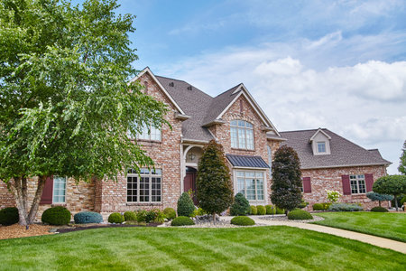 Luxury Suburban Home with Manicured Lawn and Brick Facadeの写真素材