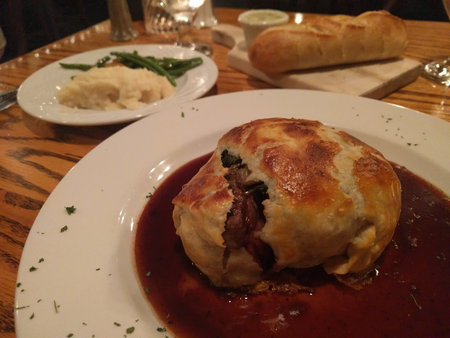 Gourmet Beef Wellington with Sides on Restaurant Tableの写真素材