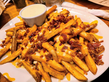 Crispy loaded fries with cheddar and bacon, served with ranch, in Fort Wayne, capturing indulgence...