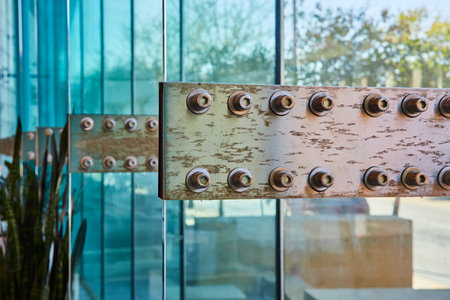 Weathered metal beam with bolts contrasts with reflective glass, Grand Wayne Convention Center,...