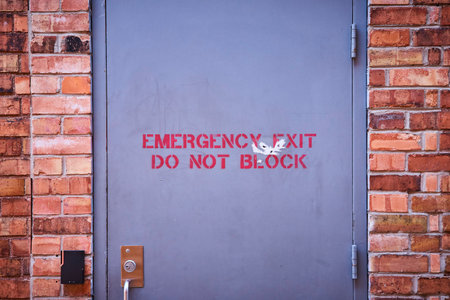 Weathered Emergency Exit on Brick Wall, Eye-Level Viewの写真素材