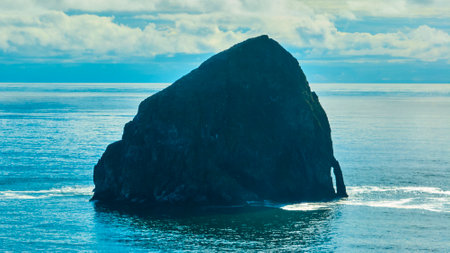 Aerial Tilt of Majestic Coastal Rock Formation in Tranquil Seascapeの写真素材
