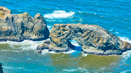 Aerial Fly Over Rugged Rocks and Churning Ocean Wavesの写真素材