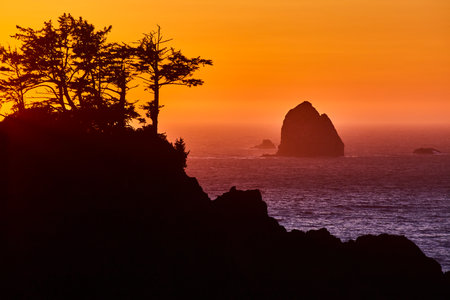 Sunset Over Rugged Cliffs and Sea Stack in Samuel H. Boardman Corridorの写真素材