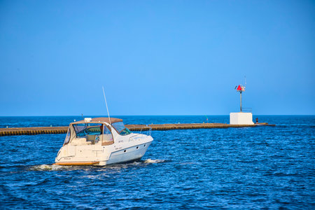 Motorboat on Calm Lake Michigan Waters Near Breakwater with Human Elementの写真素材