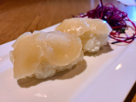 Scallop Sushi on White Plate Eye-Level Close-Upの写真素材