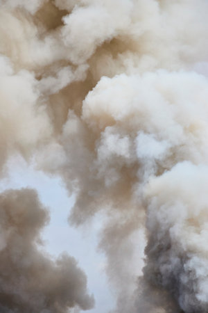 Thick Smoke Billowing from Scrap Metal Fire Upward View