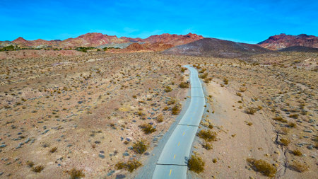 Aerial Road Through Nevada Desert to Rugged Mountainsの写真素材