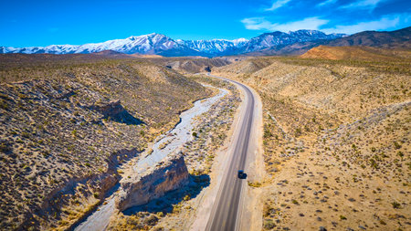 Aerial Desert Road with Snowy Mountains in Nevada Vast Landscapeの写真素材