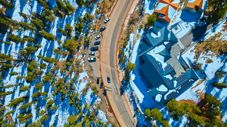 Aerial of Snowy Modern Building with Solar Panels in Mountain Landscape