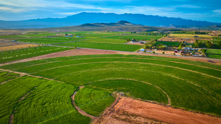 Aerial Pivot Irrigation Circle and Farmland with Mountain Backdrop Fly Overの写真素材