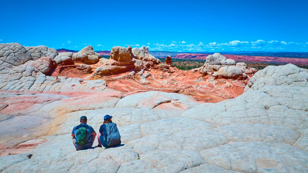 Hikers Resting on White Pocket Sandstone Vermilion Cliffs Landscape Eye Levelの写真素材