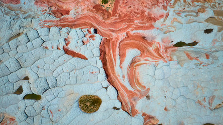 Aerial Swirling Sandstone Bands and Cracked White Rock Texture Fly Overの写真素材