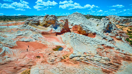 Aerial White Pocket Sandstone Formations with Hikers and Dramatic Sky Fly Overの写真素材